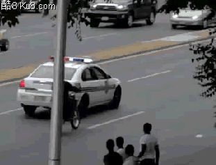 GIF动态图：男子骑着摩托车踢警车